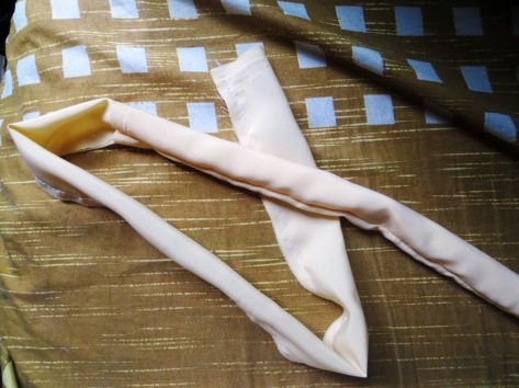 buatlah tali tas dengan cara memotong kain panjang, melipatnya memanjang, menjahit pinggirannya, lalu membaliknya agar jahitan tidak kelihatan..